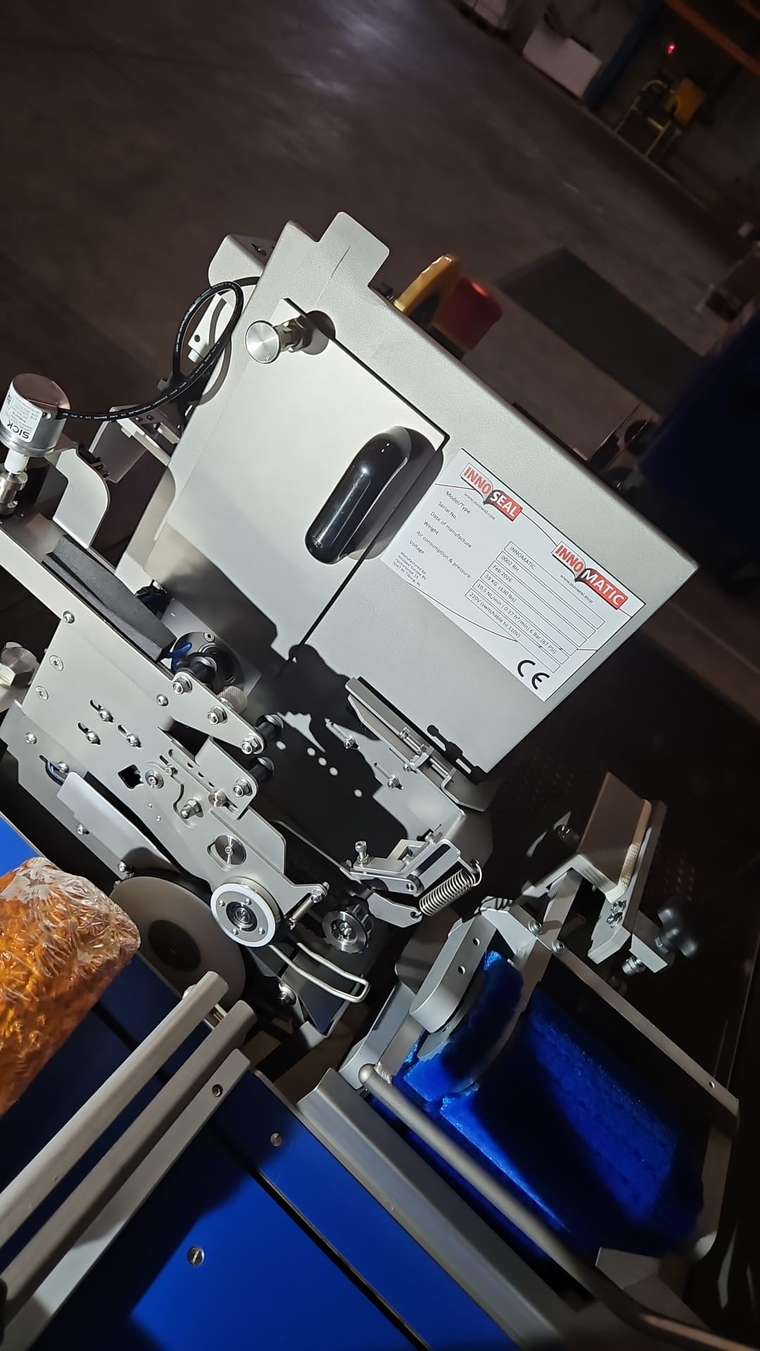 Innomatic sealing machine close-up in production facility showing mechanical components